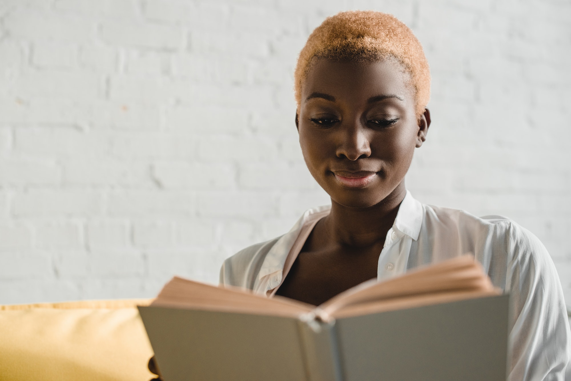 close up of african american woman with short hair reading book