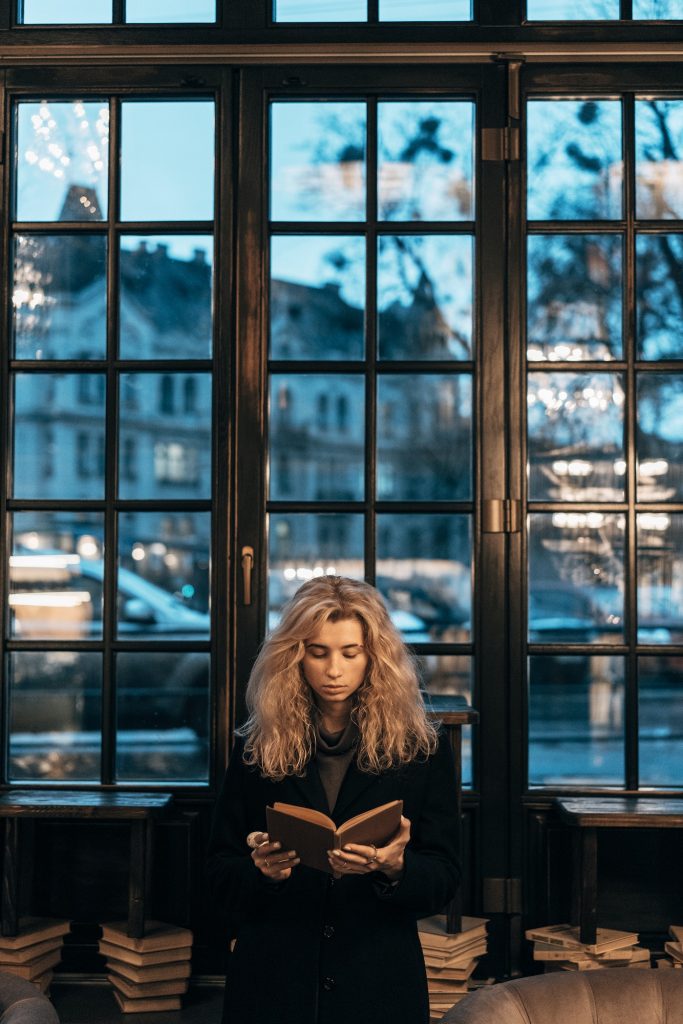 Woman reading a book on the background of window